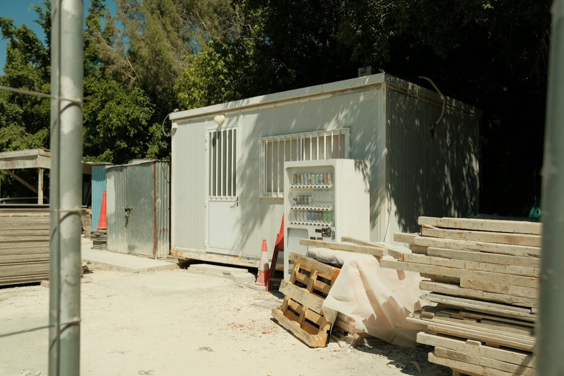 Baustelle mit Bürocontainer und gestapeltem Baumaterial