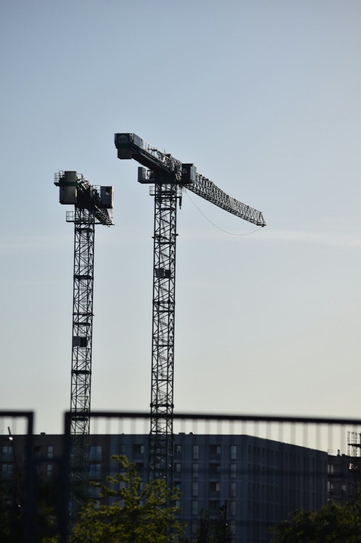 Zwei Turmdrehkrane über einer Baustelle